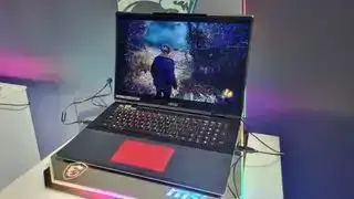 De MSI Titan 18 HX met zijn touchpad rood verlicht, op een voetstuk