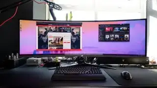 Asus ROG Swift OLED PG49WCD uzstādīts uz spēļu galda.