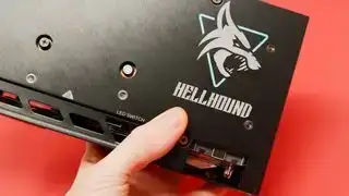 „PowerColor Hellhound RX 7600 XT“ vaizdo plokštė raudoname fone,