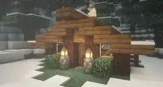 Minecraft cabin build idea - Isang napakaliit na spruce cabin na may mga lantern sa harapan sa isang kagubatan sa snow.